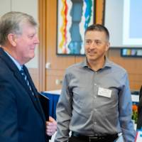 President Haas speaking with two men.